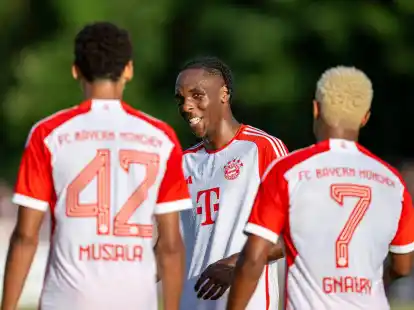 Bayerns Spieler Jamal Musiala (l-r), Mathys Tel und Serge Gnabry bejubeln den M&uuml;nchner Sieg.