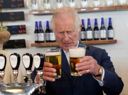 Mit Kennerblick: Prinz Charles vergleicht unterschiedlich gut gezapfte Biere in St. John's in Kanada. (Paul Chiasson/The Canadian Press via AP/dpa)