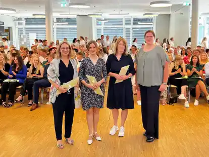 Ana Alonso Alvarez (Jahrgangsbeste der FSS, von links), Linda Herpel (Jahrgangsbeste der BQS), Sigrid Th&ouml;lking (Jahrgangsbeste der FSS) sowie Anna Tepe (Koordinatorin f&uuml;r den Fachbereich) vor den erfolgreichen Absolventinnen und Absolventen.