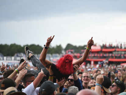Auf H&auml;nden durch die Menge getragen: eine Frau beim &bdquo;Crowdsurfing&ldquo; vor der &bdquo;Fire Stage&ldquo; beim Deichbrand-Festival. An allen drei Festival-Tagen werden 60.000 Besucher auf dem Gel&auml;nde am Seeflughafen Cuxhaven/Nordholz erwartet.