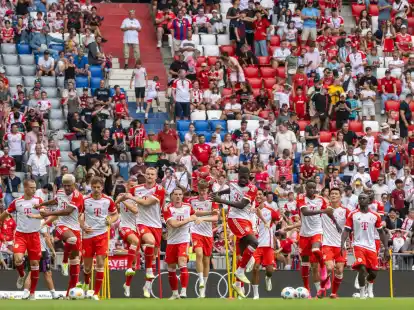 Die Spieler des FC Bayern M&uuml;nchen laufen sich bei einer Trainingseinheit w&auml;hrend der Saisoner&ouml;ffnung in der Allianz Arena warm.