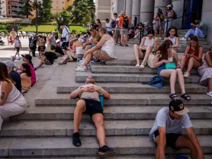 Menschen ruhen sich an einem hei&szlig;en und sonnigen Sommertag in Madrid aus.