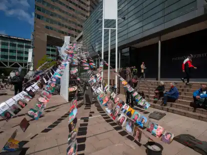 Fotos von Kl&auml;gern h&auml;ngen vor einem Gericht in Den Haag, in dem ein Klimaprozess gegen den &Ouml;l- und Erdgaskonzern Shell stattfindet (Archivbild).