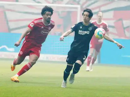 D&uuml;sseldorfs Emmanuel Iyoha (l) setzt den Hannoveraner Sei Muroya unter Druck.