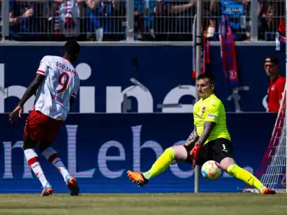 Regensburgs Prince Owusu (l) in Aktion gegen Heidenheims Torwart Kevin M&uuml;ller.