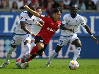 Wiesbadens Hyunju Lee (M) und die Magdeburger Silas Gnaka (l) und Amara Cond&eacute; k&auml;mpfen um den Ball.