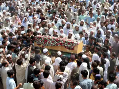 Trauernde nehmen in Bajur an der Beerdigung von Opfern der Bombenexplosion teil.