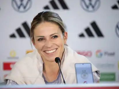 Nationalspielerin Melanie Leupolz sitzt w&auml;hrend einer Pressekonferenz auf dem Podium.