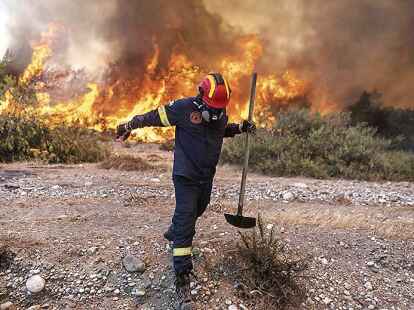 Bilder wie dieses gingen durch die Medien: Ein Feuerwehrmann verlie&szlig; das Dorf Vati auf der Ferieninsel Rhodos, als die Flammen des Waldbrandes auf ihn zukamen.