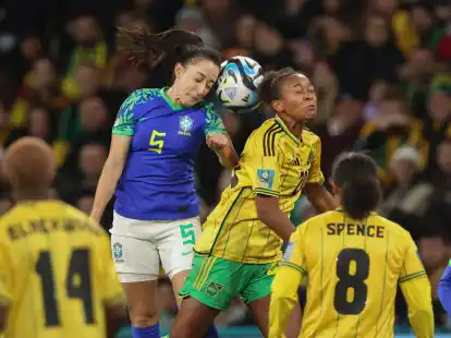Die Brasilianerin Luana (l) und die Jamaikanerin Atlanta Primus (M) liefern sich ein Kopfballduell.