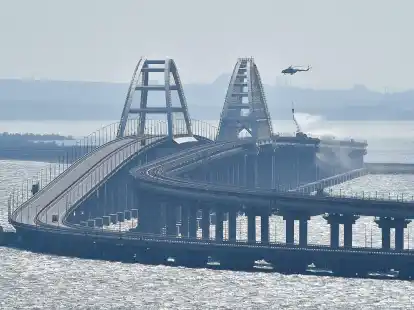 Ein Hubschrauber wirft Wasser ab, um ein Feuer auf der Krim-Br&uuml;cke, die das russische Festland und die Halbinsel Krim &uuml;ber die Meerenge von Kertsch verbindet, zu l&ouml;schen.