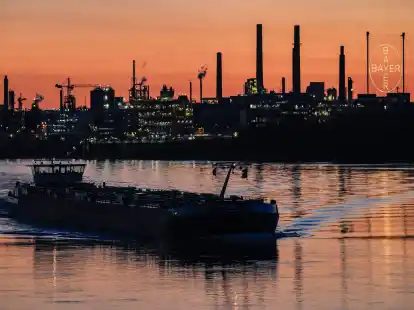Ein Schiff f&auml;hrt &uuml;ber den Rhein vor dem Bayer-Werk in Leverkusen. Der Konzern senkt seine Prognose auch f&uuml;r die Pharmasparte.
