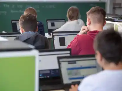 Sch&uuml;lerinnen und Sch&uuml;ler nehmen im Klassenzimmer einer 9. Klasse am Unterricht mit Hilfe von Laptops und Tablets teil.