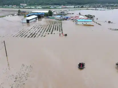 Rettungskr&auml;fte suchen auf einem Boot nach vermissten Personen im Hochwasser, nachdem der Tropensturm &laquo;Khanun&raquo; auf Land getroffen ist.