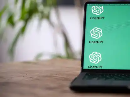 Die ChatGTP-Logos auf dem Monitor des Laptops zeigen, dass hier mit K&uuml;nstlicher Intelligenz gearbeitet wird.