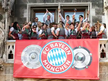 Spielerinnen und Spieler von Bayern M&uuml;nchen jubeln auf dem Rathaus-Balkon.