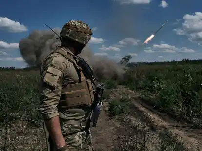 Ein ukrainischer Soldat beobachtet, wie ein Grad-Mehrfachraketenwerfersystem in der N&auml;he von Bachmut Raketen abfeuert.