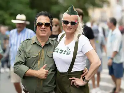 Zwei Besucher des Elvis-Festivals laufen &uuml;ber das Freigel&auml;nde.