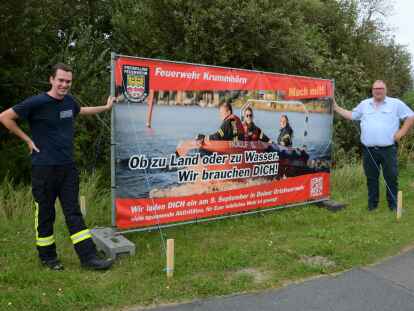 Feuerwehrsprecher Kilian Peters (links) und Gemeindebrandmeister Jan-J&uuml;rgen L&uuml;pkes pr&auml;sentieren eines der sieben neuen Werbebanner, mit der die Feuerwehr Krummh&ouml;rn neue Mitglieder sucht.