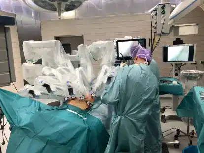 Operation mit Roboter: &Uuml;ber dem Patienten sind die Operationsarme aufgebaut. Gesteuert werden sie aus mehreren Metern Entfernung von einem speziell geschulten Chirurgen &uuml;ber eine High-Tech-Computerkonsole.