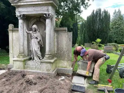 Schwere Arbeit: Die Bestandteile der Sandsteinumrandung wurden abgebaut, gereinigt und dann wieder aufs Grab gesetzt.