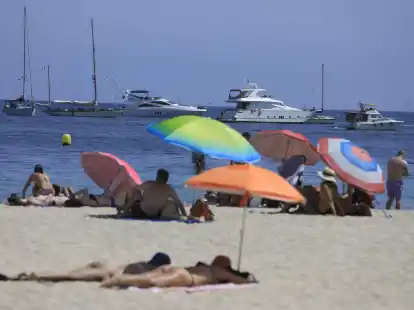 Menschen sonnen sich am Strand von Magaluf.