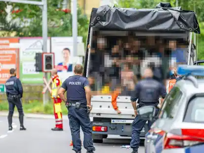 Polizisten stehen bei einer Kontrolle in &Ouml;sterreich an einem Kleintransporter. Die Beamten entdeckten dabei 53 Personen auf der Ladefl&auml;che.