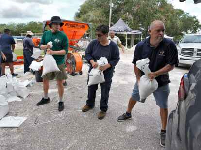 Mitarbeiter der Park- und Freizeitbeh&ouml;rde von Tampa in Florida helfen Anwohnern beim Verladen von Sands&auml;cken.