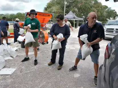 Mitarbeiter der Park- und Freizeitbeh&ouml;rde von Tampa in Florida helfen Anwohnern beim Verladen von Sands&auml;cken.