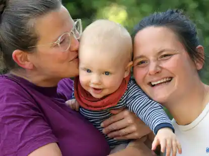 Juliane (l-r), der zehn Monate alte Remo und Jana in ihrem Garten hinter ihrem Haus in Berlin.