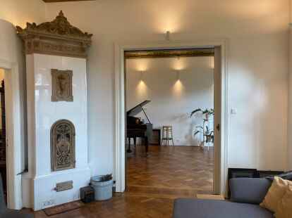 Blick vom Wohnzimmer mit Kachelofen in den Salon.