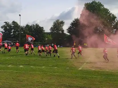 Begleitet von lauter Rockmusik und mit großen Tigers-Fahnen: So stürmten die Jugendlichen der Emder Tigers durch roten Rauch auf das Spielfeld.