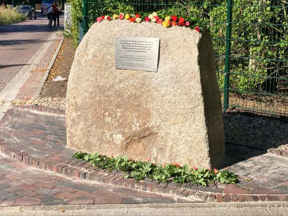 Viele Rosen sind beim frisch enth&uuml;llten Gedenkstein niedergelegt worden. Bild: Hoffmeier