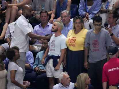 Ein Sicherheitsbeamter (l) konfrontiert drei Umweltaktivisten w&auml;hrend des Halbfinalspiels zwischen Coco Gauff und Karolina Muchova.