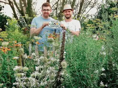 Das Emailleschild weist den Garten von Torsten Tjarks (rechts) und Malte Schoon als naturfreundlich aus.