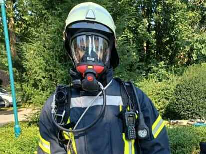 Trotz der hohen Temperaturen schl&uuml;pfte ein Feuerwehrmann der Wehr Krummh&ouml;rn-Ost in seine Atemschutzmontur.