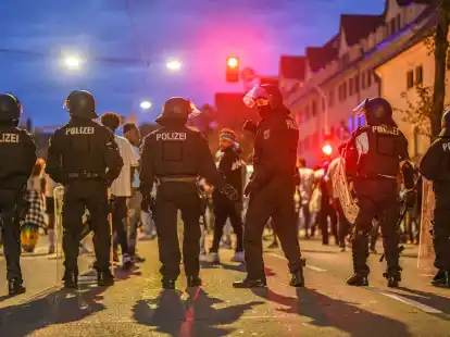 Eine Gruppe von Menschen wird nach Ausschreitungen bei einer Eritrea-Veranstaltung von Polizeikr&auml;ften eingekesselt.