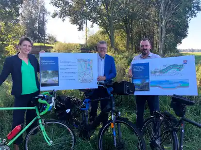 Tomke van Lessen, B&uuml;rgermeister Theo Douwes und Marco Smid auf der Gr&uuml;nfl&auml;che am Esklumer Sieltief, auf der der neue Radweg verlaufen wird.