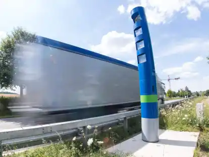 Ein Lastwagen f&auml;hrt auf einer Bundesstra&szlig;e an einer Mauts&auml;ule vorbei.