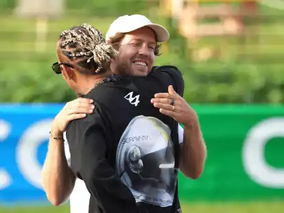 Lewis Hamilton (vorne) und Sebastian Vettel begr&uuml;&szlig;en sich im Rahmen des &laquo;Buzzin' Corner&raquo;-Projekt, dass das Bewusstsein f&uuml;r die Artenvielfalt sch&auml;rfen soll.