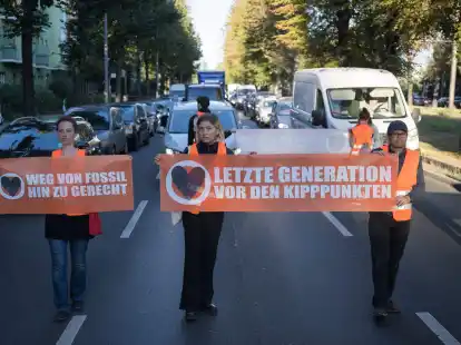 Statt sich auf die Stra&szlig;e zu setzen oder festzukleben, hielten Demonstrantinnen und Demonstranten heute ogenannte Laufblockaden ab und gingen mit Bannern vor dem Verkehr her.