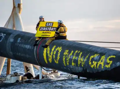 Umweltschutzaktivisten von Greenpeace sitzen auf der Pipeline.