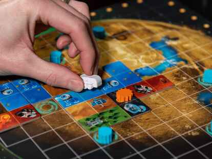 In dem Pl&auml;ttchenlegespiel &laquo;Planet Unknown&raquo; muss der eigene Planet m&ouml;glichst clever voll gepuzzelt werden. (Strohmann Games/dpa-tmn)