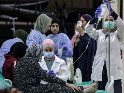 Libanesisches medizinisches Personal versorgt eine &auml;ltere Frau, die Opfer eines Choleraausbruchs geworden ist.