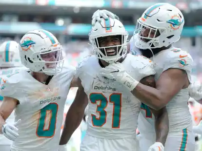 Raheem Mostert (M) jubelt mit seinen Teamkollegen Braxton Berrios (l) und Christian Wilkins (r) &uuml;ber seinen Touchdown.
