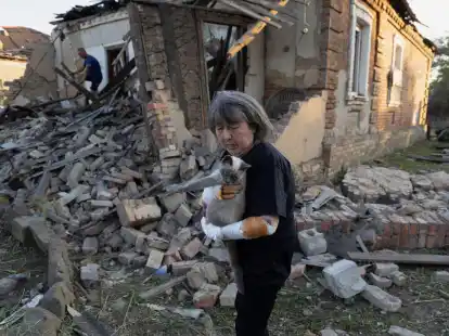 Eine Anwohnerin steht vor ihrem Haus in Kostjantyniwka in der Region Donezk, das durch einen Raketenangriff besch&auml;digt wurde.