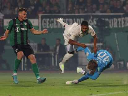 M&uuml;nsters Torwart Johannes Schenk (r) im Kampf um den Ball mit M&uuml;nchens Serge Gnabry (M), der sich dabei verletzt.