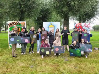 Mit der Hilfe von Malte Schneider (hinten, 4. v. r.) kreierten die Jugendlichen bunte Gem&auml;lde.