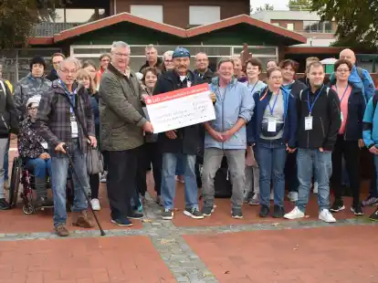 Unmittelbar vor dem Start in Richtung Slagharen &uuml;berreichte Gerd Thellmann von der Bl&uuml;cher-Stiftung &bdquo;Kinder in Not&ldquo; auf dem Wittmunder Marktplatz einen symbolischen Scheck an den Lebenshilfe-Vorsitzenden Thomas Hullena.