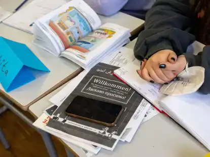 Ein M&auml;dchen aus der Ukraine sitzt mit ihrem Unterrichtsmaterial in einer Klasse.